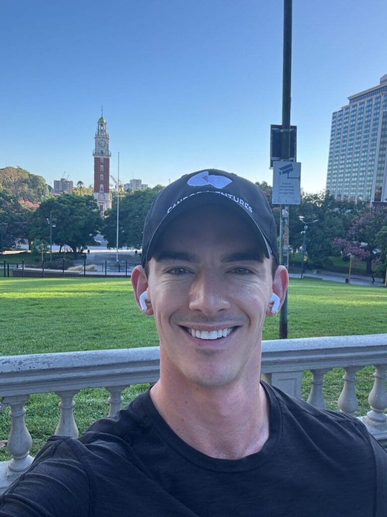 Noah Berkson taking a selfie in a Buenos Aires park, with the Torre Monumental clock tower in the background